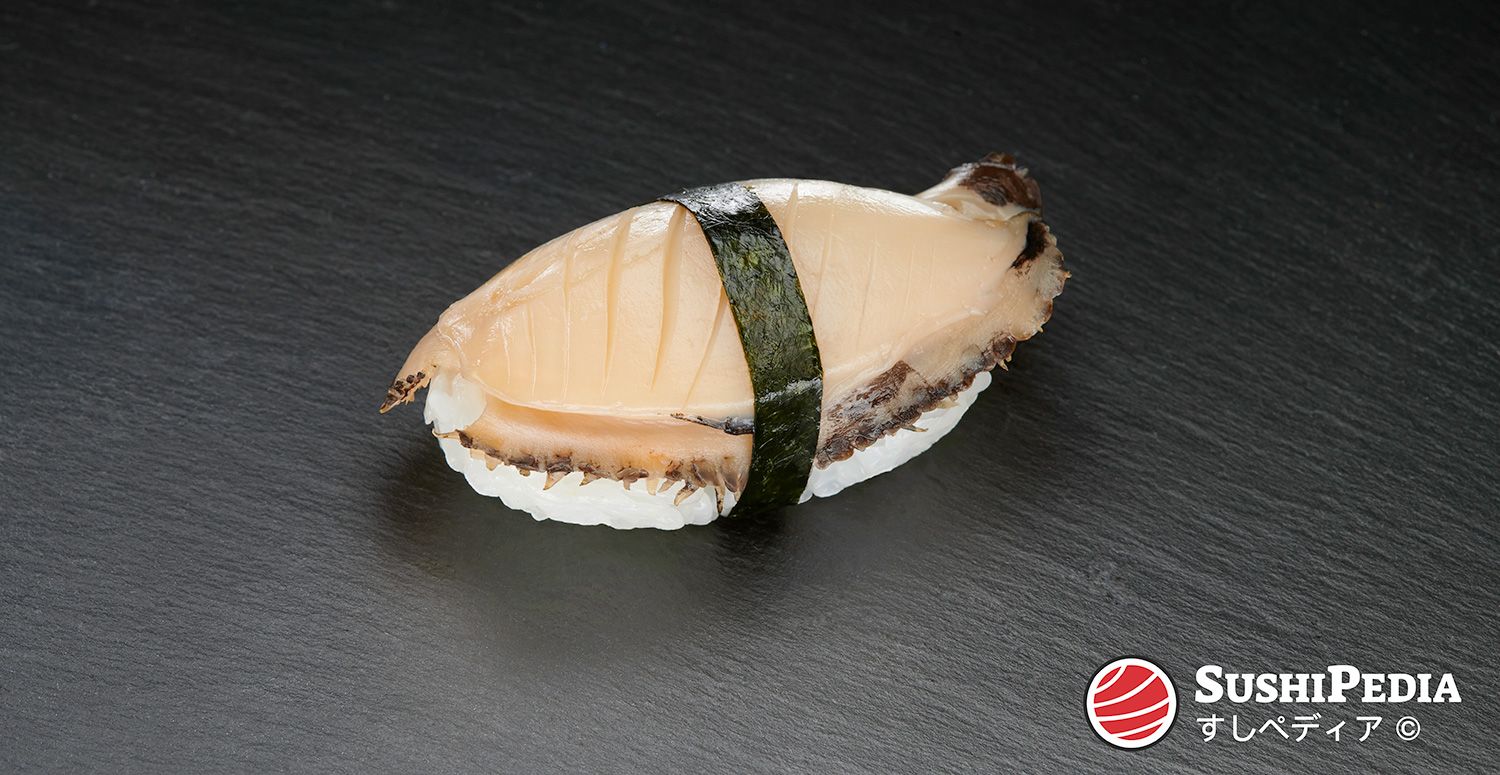 A freshly prepared nigiri sushi (palm sushi) with the main ingredient, known as "awabi" in Japanese, rests on a stone plate.
