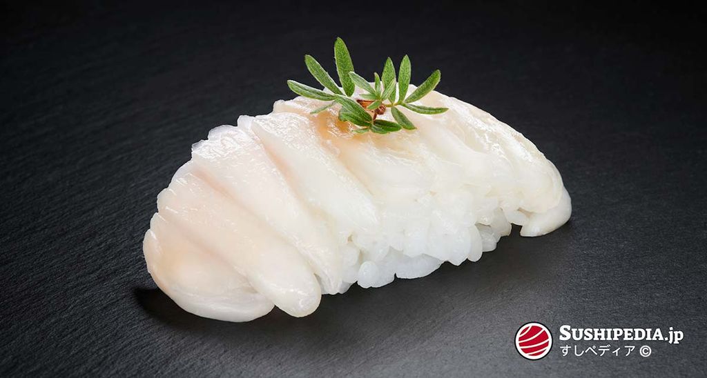 Engawa sushi, elegantly garnished with a sprig of green shiso against a black background.