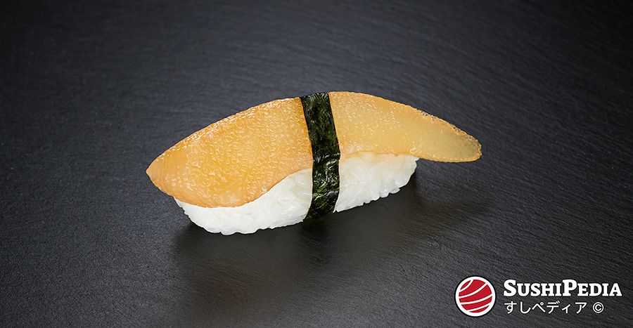 A freshly prepared piece of nigiri sushi with herring roe (Japanese kazunoko) lies on a stone plate.
