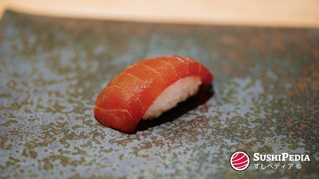 Maguro Zuke Nigiri sushi, soy sauce marinated, on a textured background