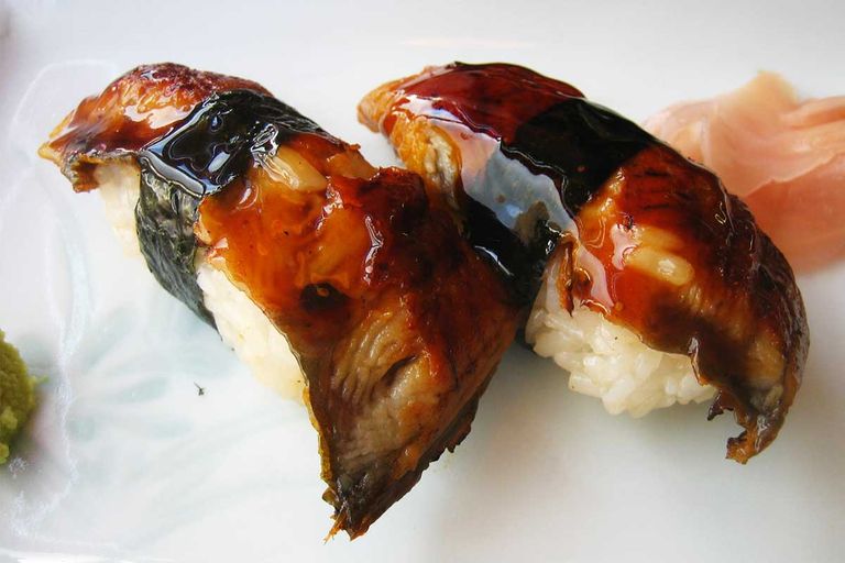 Two pieces of eel (unagi) sushi on a plate.