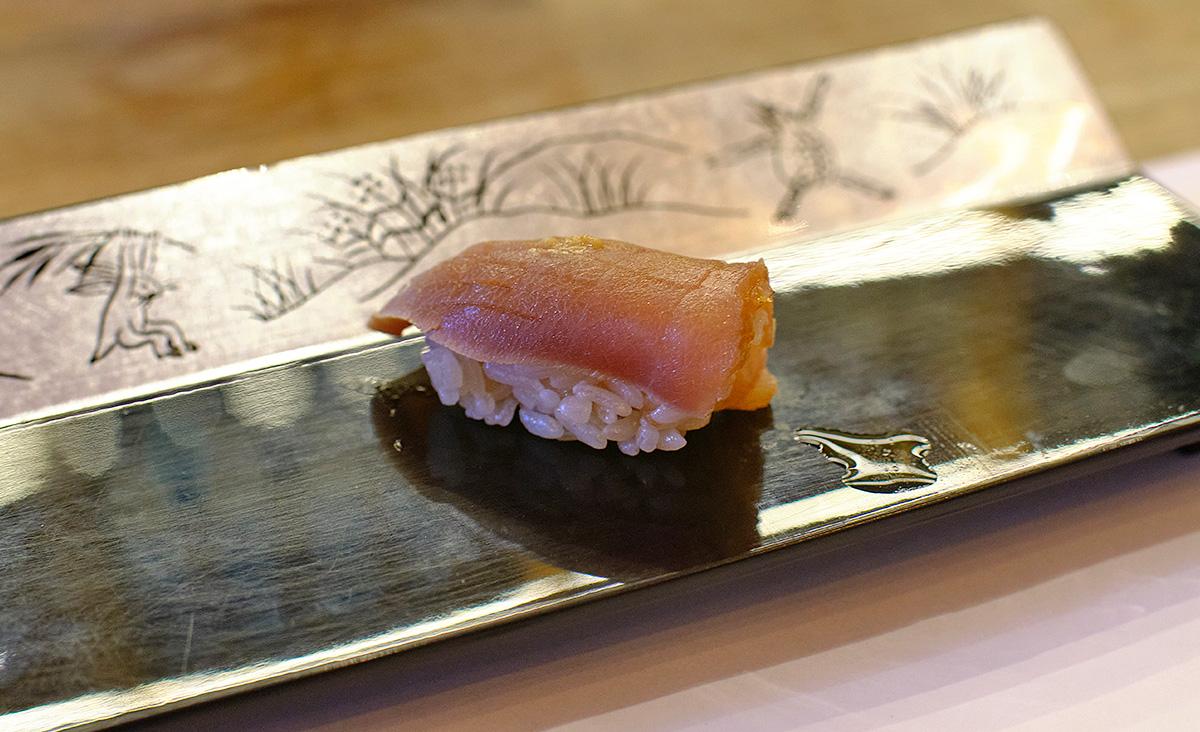 Meat of bluefin tuna that has been aged for several days and then soaked in soy sauce. Prepared as nigiri sushi. 
				D. Schilder. 
				Zuke Maguro Sushi. 
				
				copyrighted ©. 
				