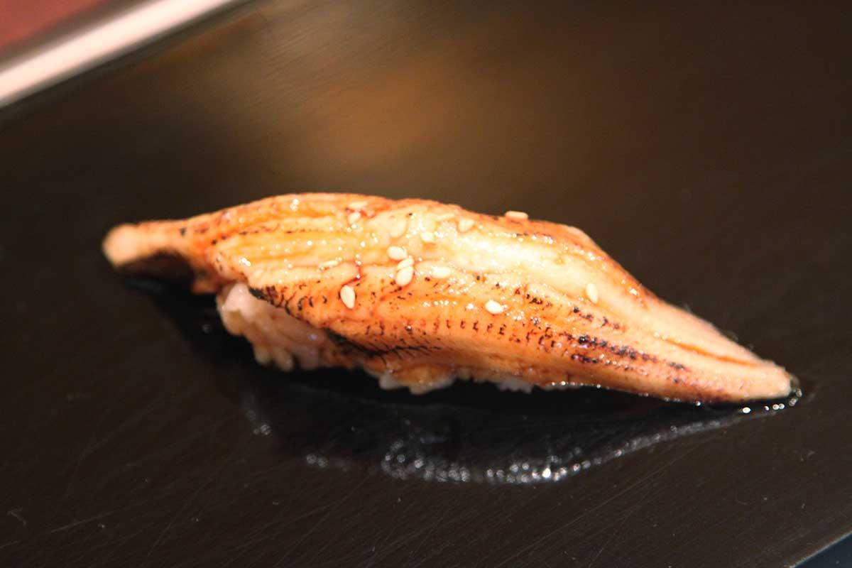 Eel (unagi) sushi on a plate. 
				takaokun. 
				IMG_5614 Unagi Nigiri. 
				flickr.com. 
				Attribution 2.0 Generic (CC BY 2.0). 
				