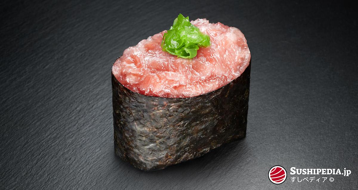 A photo that shows the negi toro of bluefin tuna placed inside a gunkan maki.